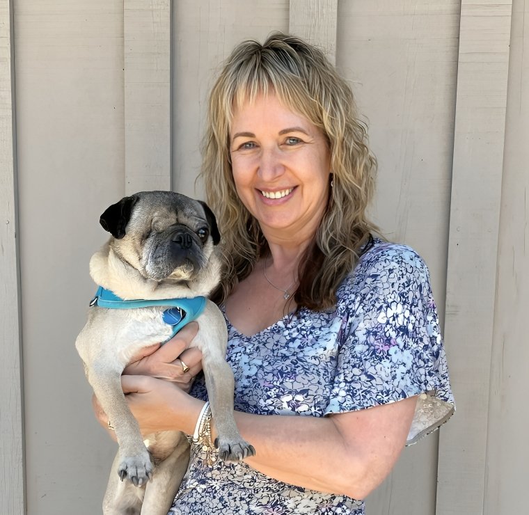 New Project Smiling woman holding a pug dog.